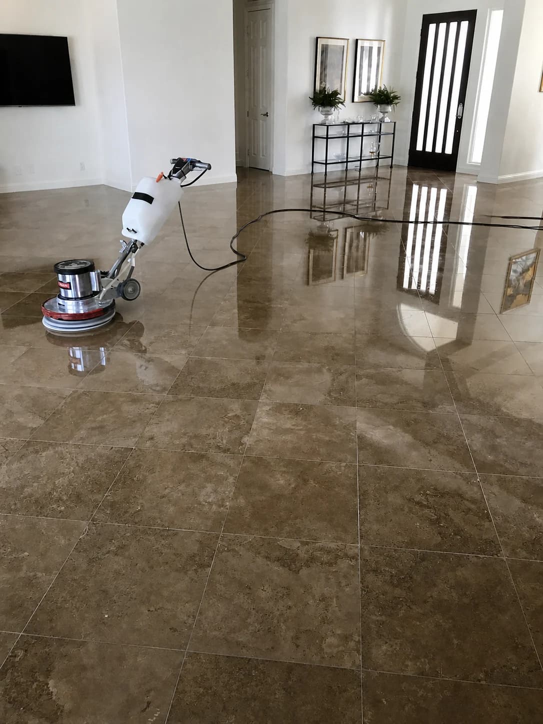 Machine de nettoyage sur sol en pierre naturelle brillant dans une villa