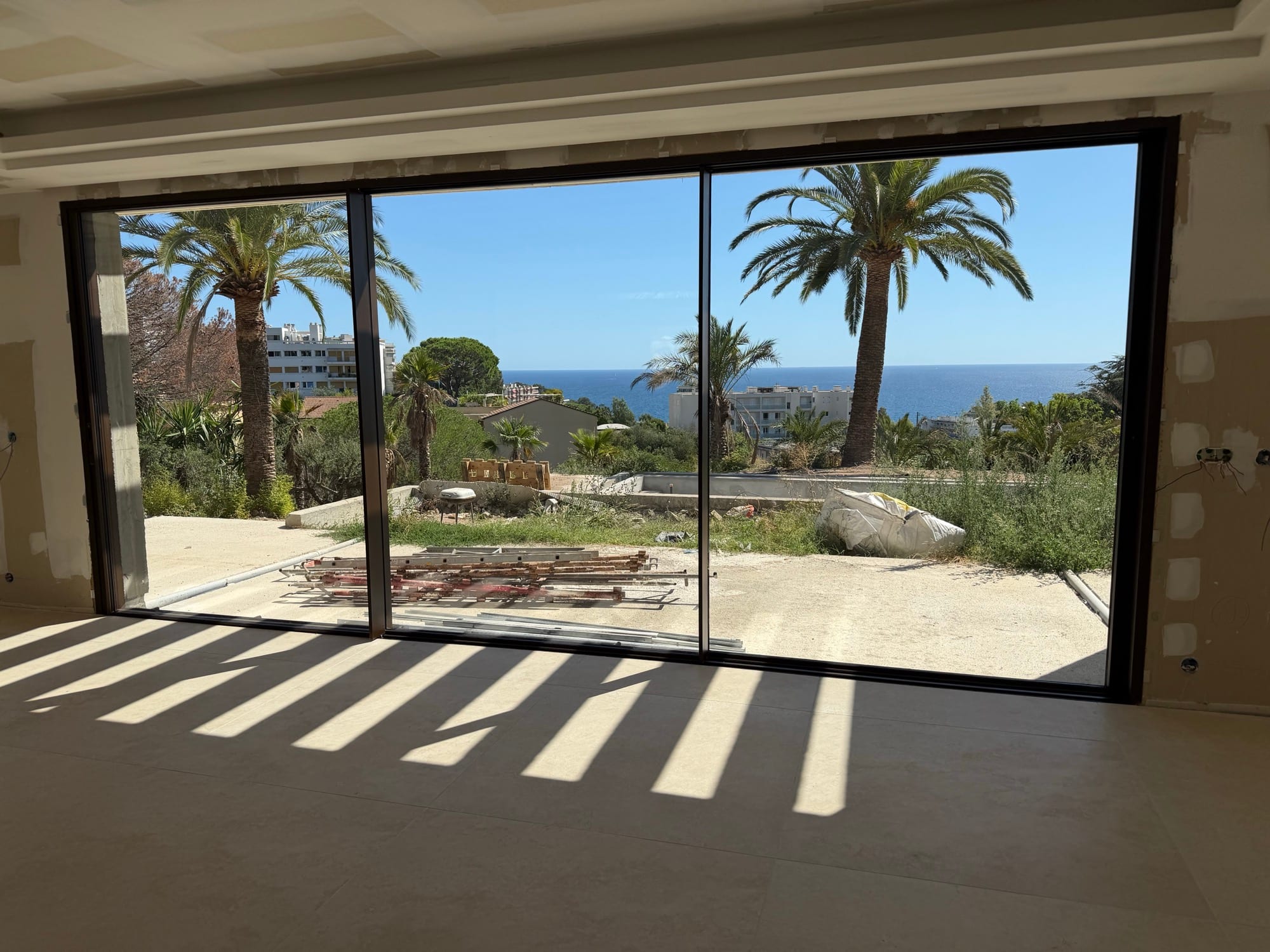 Grande baie vitrée d’une villa de la Côte d’Azur avec vue mer