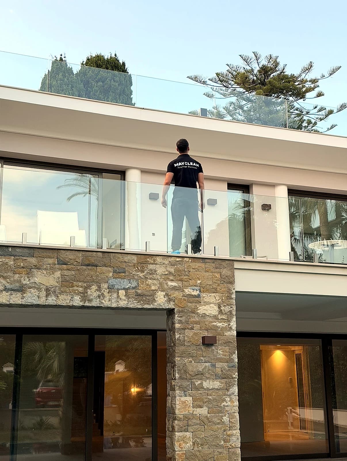 Nettoyage d'un garde-corps vitré dans une villa